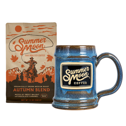 Summer Moon Coffee Autumn Blend coffee bag next to a blue glazed ceramic mug with a matching brand logo patch.