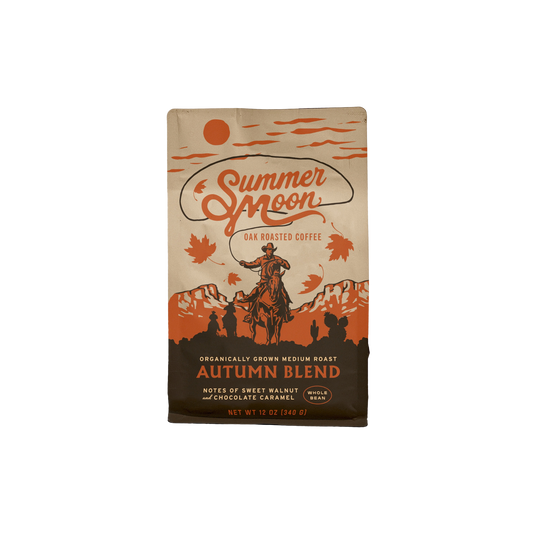 A bag of Summer Moon Autumn Blend Oak Roasted Coffee on a plain white background. The packaging features a vintage western design with an illustration of a cowboy on a horse, mountains, and orange autumn leaves on a tan background.